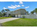 The home shows a manicured lawn and two car garage enhancing its curb appeal and functionality at 261 Kentucky Ave, Crystal Beach, FL 34681