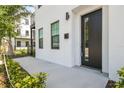 Stylish front entrance featuring a modern black door, clean white exterior, and manicured landscaping at 2758 5Th S Ave, St Petersburg, FL 33712
