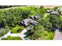 Aerial view of a well-maintained home featuring lush landscaping and a long driveway at 29903 Baywood Ln, Wesley Chapel, FL 33543