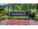 Stone welcome sign for Saddlebrook community featuring a well-maintained flowerbed and lush landscaping at 29903 Baywood Ln, Wesley Chapel, FL 33543