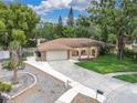 Sprawling single-story home featuring a well-manicured lawn and circular driveway at 30 Pinetree Ct, Palm Harbor, FL 34683