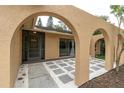 Inviting entrance to a home with stone and concrete features, complemented by arched architecture at 30 Pinetree Ct, Palm Harbor, FL 34683
