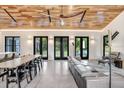Open-concept living room with hardwood ceiling, ample seating and large windows at 3440 Crenshaw Lake Rd, Lutz, FL 33548