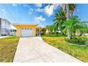 Charming single-Gathering home featuring an attached garage, driveway, and well-maintained lawn at 365 La Hacienda Dr, Indian Rocks Beach, FL 33785