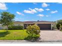 Beautiful single-story home featuring a red tile roof, lush landscaping, and a brick paved driveway at 4425 13Th Ne Way, St Petersburg, FL 33703