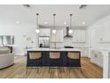 Bright kitchen with a stylish island, modern pendant lighting, stainless appliances, and hardwood floors at 4757 Legacy Park Dr, Tampa, FL 33611