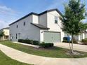 Beautiful two-story townhome featuring a gray garage door and manicured lawn at 5310 Companion Ln, Tampa, FL 33619