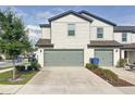 Charming townhome with a gray garage door and landscaped yard at 5310 Companion Ln, Tampa, FL 33619