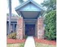 Inviting entryway with brick pillars and a covered porch leading to the decorative front door at 625 Fayette S Dr, Safety Harbor, FL 34695