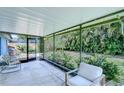 Enclosed patio featuring a concrete floor, comfortable seating, and views of the tropical backyard at 7107 Colonial Lake Dr, Riverview, FL 33578
