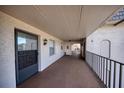 Hallway leading to unit, featuring stucco walls, carpeted floor, and black iron railings offering an inviting entrance at 712 Cordova Greens # 712, Largo, FL 33777