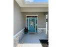 Elegant teal front door framed by sidelights and a transom window, set within a decorative stone facade at 7635 N 55Th N St, Pinellas Park, FL 33781