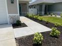 Landscaped walkway leading to the home's entrance, featuring well-maintained plantings and attractive curb appeal at 7635 N 55Th N St, Pinellas Park, FL 33781