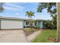 Charming single-story home featuring a well-maintained lawn, lush landscaping, and a two car garage at 811 Woodley Rd, Clearwater, FL 33764