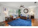 Cozy living room showcasing hardwood floors, plantation shutters, and a ceiling fan at 811 Woodley Rd, Clearwater, FL 33764