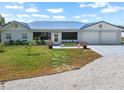 Charming home exterior with a well-manicured lawn, inviting entrance, and a convenient two-car garage at 100 18Th Nw St, Ruskin, FL 33570