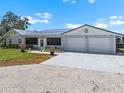 Inviting home exterior with lush landscaping, a manicured lawn, and a spacious driveway leading to a two-car garage at 100 18Th Nw St, Ruskin, FL 33570