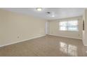 Bright, open living room with tile flooring and plenty of natural light at 12817 Lake Tree Ln, Hudson, FL 34669