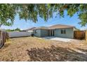 Spacious backyard with a concrete patio, partial fence, and ample room for outdoor activities at 1408 Birchstone Ave, Brandon, FL 33511