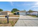 Inviting single-story home boasts a well-kept lawn, large driveway, and convenient two-car garage at 1408 Birchstone Ave, Brandon, FL 33511