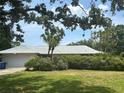 Charming single-story home with lush landscaping, mature trees, and an attached two-car garage at 1445 72Nd Ne Ave, St Petersburg, FL 33702
