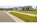 Exterior street view showcasing the home's manicured lawn and neighborhood setting, with similar-style houses at 14498 Whitewater Way, Brooksville, FL 34604