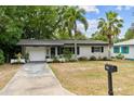 Charming single-story home with mature trees and a well-maintained lawn at 1526 San Mateo Dr, Dunedin, FL 34698