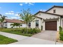 Beautiful house with brick paver driveway, tile roof and lush, green landscaping in a serene setting at 17222 Holly Well Ave, Wimauma, FL 33598