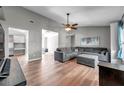 Spacious living room with hardwood floors, ceiling fan, and comfortable gray sectional sofa at 1851 Skyland Dr, Clearwater, FL 33759