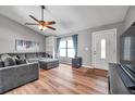Bright living room featuring hardwood floors, a ceiling fan, and a cozy gray sectional sofa at 1851 Skyland Dr, Clearwater, FL 33759