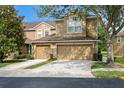 Inviting tan two-story home featuring a two-car garage and well-maintained landscaping at 18939 Duquesne Dr, Tampa, FL 33647