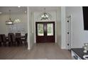 Elegant foyer features double doors with glass inserts, light hardwood floors and an archway at 1961 Dunbrody Ct, Dunedin, FL 34698