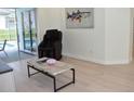 Modern living room featuring hardwood floors, a marble top table and sliding glass doors at 1961 Dunbrody Ct, Dunedin, FL 34698