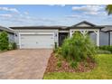 Charming single-Gathering home with a well-manicured lawn, brick driveway, and attached two-car garage at 20033 Sea Glass Cir, Land O Lakes, FL 34638