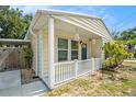 Inviting front porch with cream supports, hanging decorations, and a freshly painted dark green front door at 2604 E Chelsea St, Tampa, FL 33610