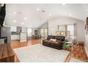 Bright open-concept living room featuring a brown leather sofa, hardwood floors, and ample natural light at 2604 E Chelsea St, Tampa, FL 33610