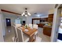 Inviting dining area with elegant chandelier, wooden table, and seamless flow into the kitchen at 306 Oak Ave, Brandon, FL 33510
