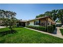 Well-maintained single-story home featuring mature trees, manicured shrubs, and inviting screened-in porch at 368 Perth Ct # 368, Dunedin, FL 34698