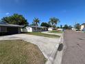 A street view showcasing a well-kept home with a nice lawn, complemented by palm trees and a driveway at 378 79Th Ne Ave, St Petersburg, FL 33702