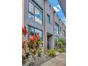 Stylish townhouse exterior with large windows reflecting the sky and modern landscaping at 4047 Gauge Line Loop, Tampa, FL 33624