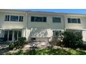 Exterior view of a multi-unit building with a patio area and garden, highlighting outdoor living at 4560 Overlook Ne Dr # 167, St Petersburg, FL 33703