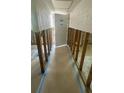 Hallway with exposed framing and unfinished walls leading to a doorway, showing renovation progress at 4560 Overlook Ne Dr # 167, St Petersburg, FL 33703