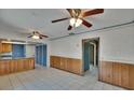 Spacious living room features two ceiling fans, wood paneling detail, and an open floor plan to the kitchen at 508 E Brentridge, Brandon, FL 33511