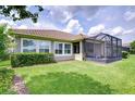 Lush backyard featuring a screened-in lanai and well-manicured lawn with garden at 5728 Watercolor Dr, Lithia, FL 33547