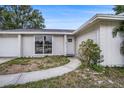 Charming home with a well-kept lawn, walkway, and inviting entrance, perfect for a Gathering at 7004 Lambright Ct, Tampa, FL 33634