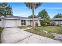 Inviting single-Gathering home with a spacious driveway, lush lawn, and a welcoming entrance at 7004 Lambright Ct, Tampa, FL 33634