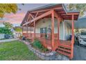 This house features a cozy front porch with wooden railings and decorative hanging chair at 7010 N Hubert Ave, Tampa, FL 33614