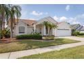Well-maintained home featuring lush landscaping, a two-car garage, and an inviting facade at 7838 Trail Run Loop, New Port Richey, FL 34653