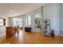 Open living space featuring hardwood floors, a bar area, and archways to other living spaces at 7838 Trail Run Loop, New Port Richey, FL 34653
