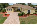 Charming single-story home featuring a brick driveway, well-maintained lawn, and inviting entrance at 8308 Mobile Cir, Weeki Wachee, FL 34613